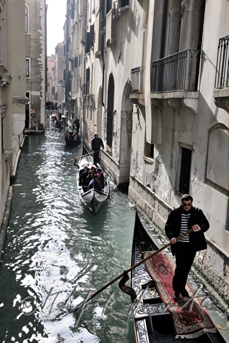 gondolier pushes off a house wall