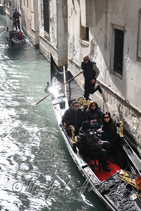 gondolier pushes off a house wall