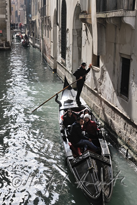 gondolier pushes off a house wall