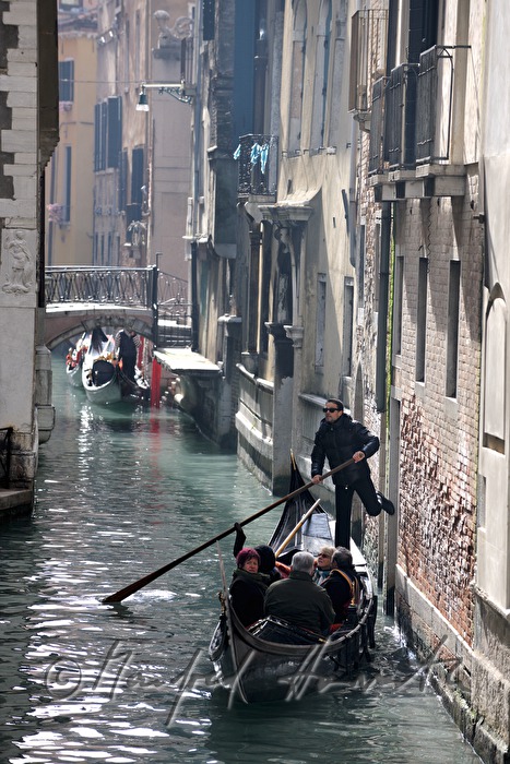 gondolier pushes off a house wall
