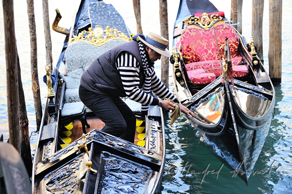 gondolier cleaning the blade on the bow