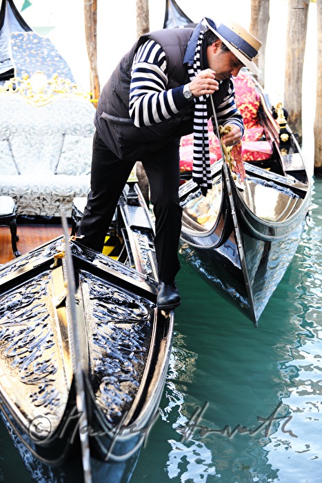 gondolier cleaning the blade on the bow