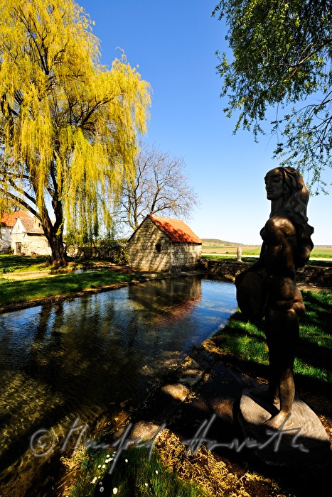 bronze sculpture and pond by the mill