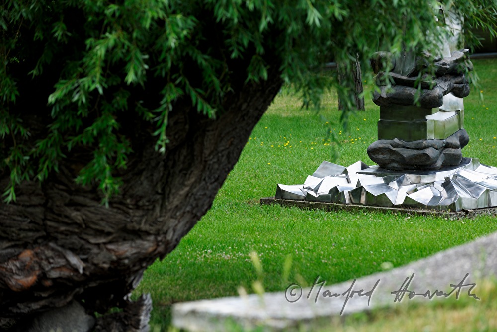 footing of a metal sculpture and willow tree