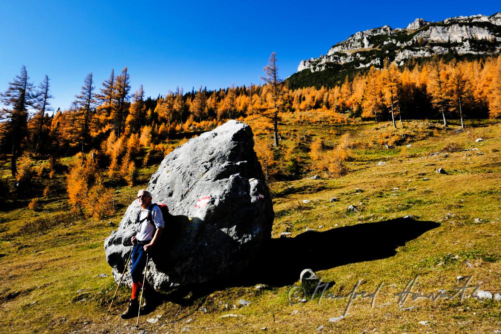 wanderer resting near a rock at the Preiner Gscheid