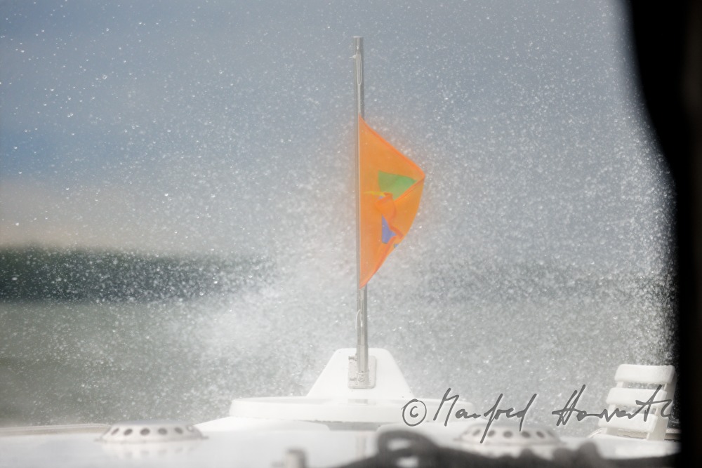bow of the houseboat and huge fountain of a wave