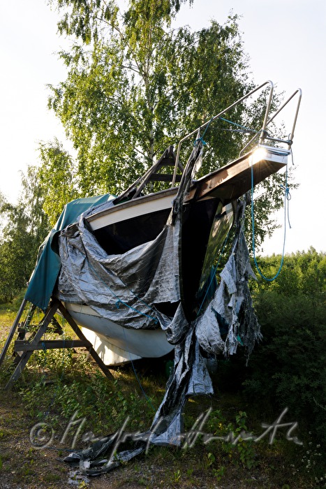 yacht on the shore with ragged covering