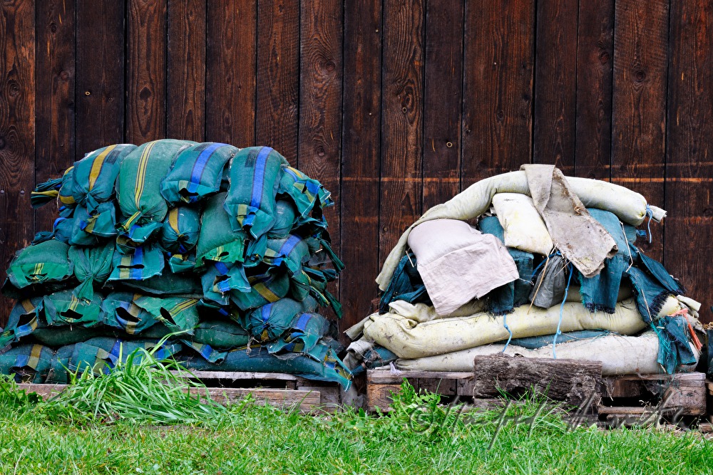 sand sacks on two panoplys in front of a wooden barn