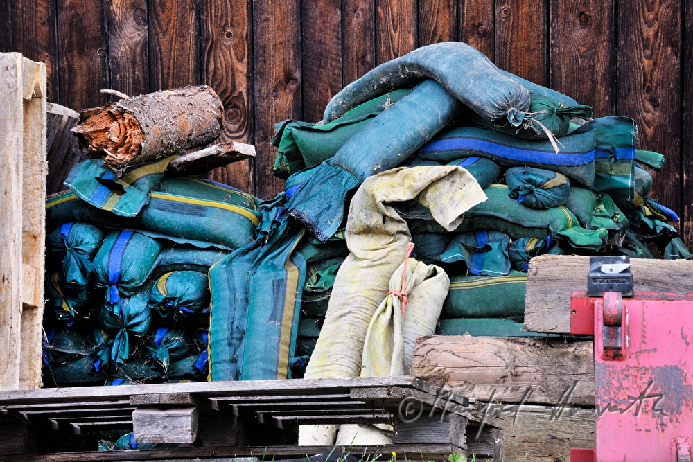 sand sacks on two panoplys in front of a wooden barn