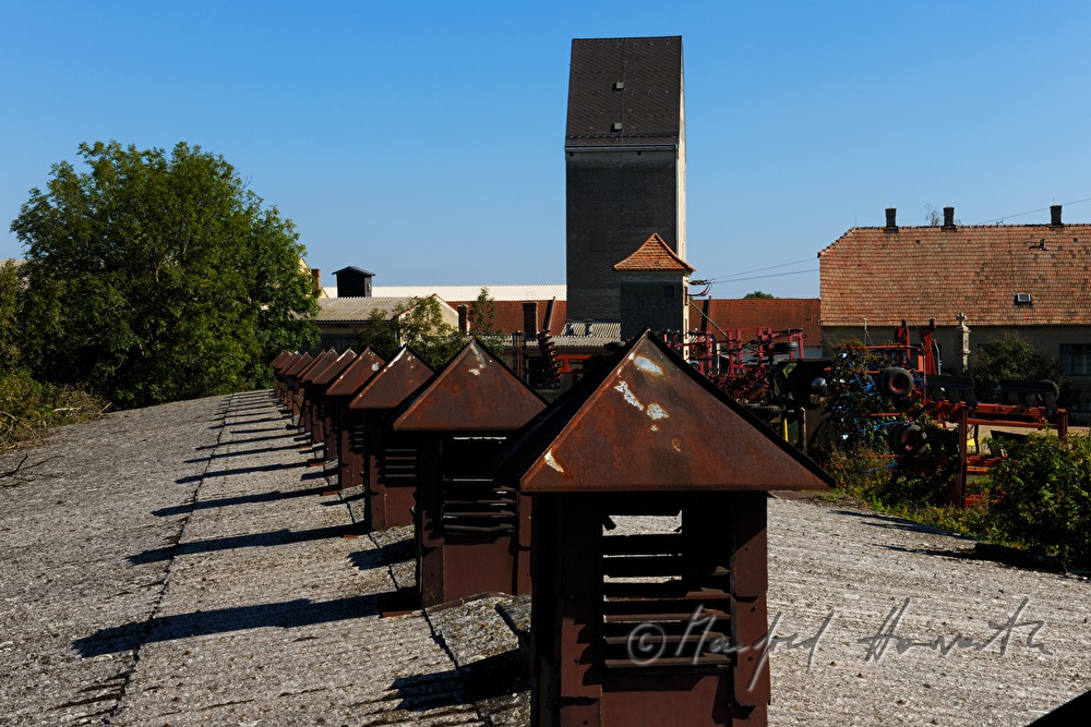 rusty ventilation hoods on the roof of a barn