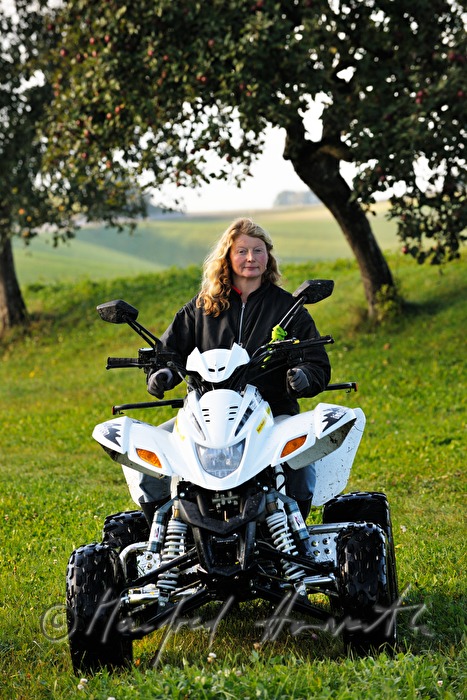 farmers wife crosses the meadow with an ATV
