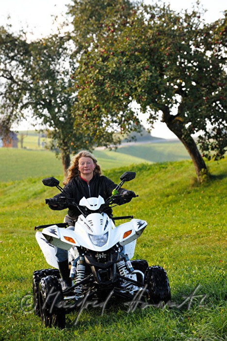 farmers wife crosses the meadow with an ATV
