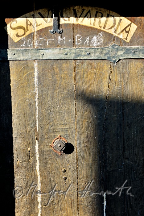 wooden door with latin script at the toll house