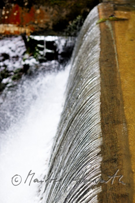 waterfall and dam near an old water mill