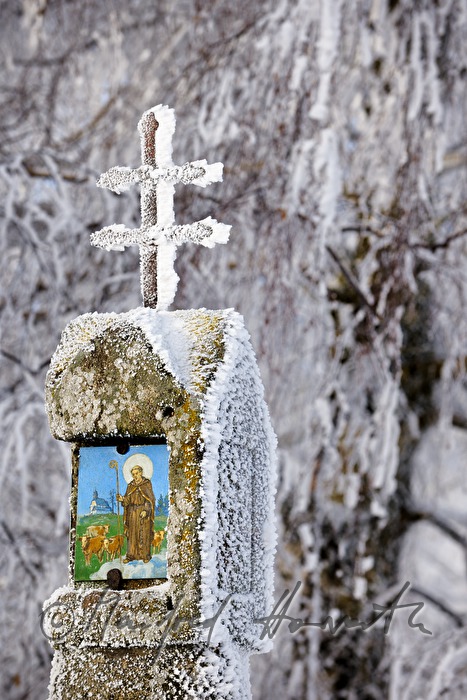wayside shrine with a double crucifx and a picture of a saint