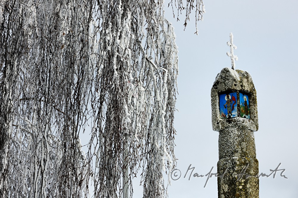wayside shrine with a double crucifx and a picture of a saint