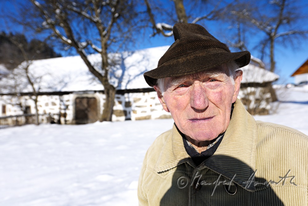 elderly villagefolk in front of a farmhouse
