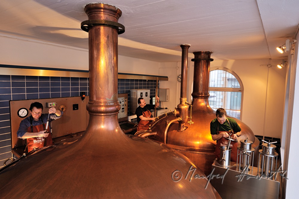 master brewer and workers brew beer in the brew house