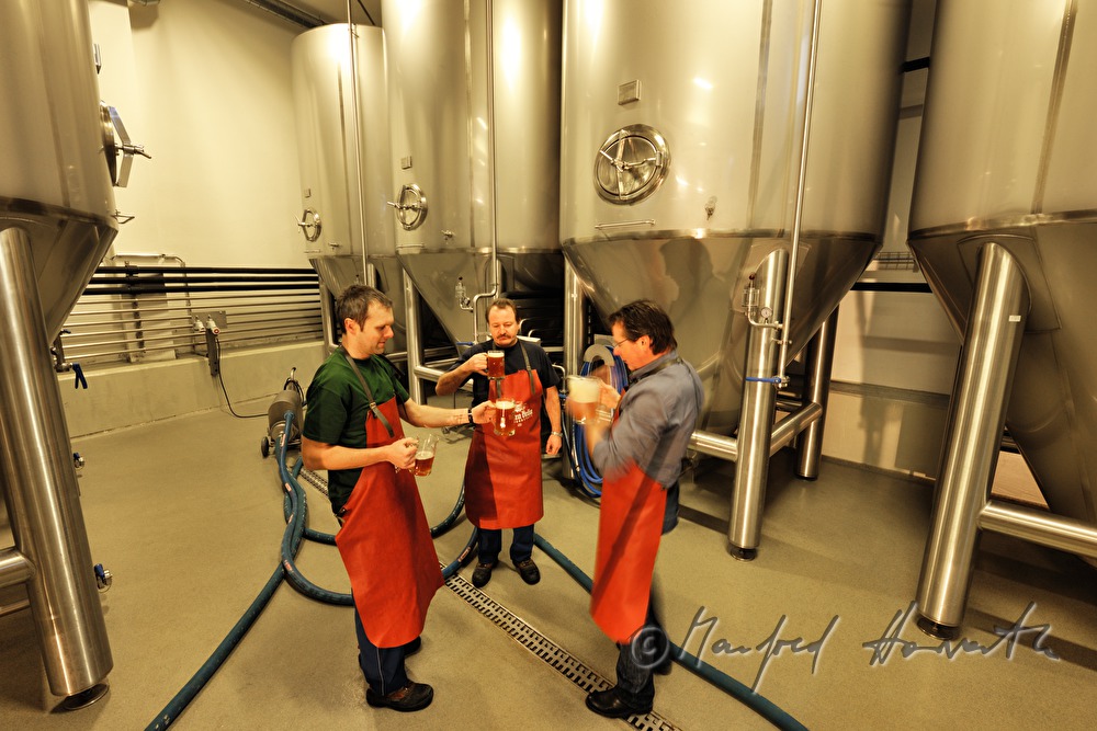 master brewer and workers tasting beer in the cellar