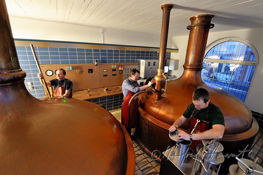 master brewer and workers brew beer in the brew house