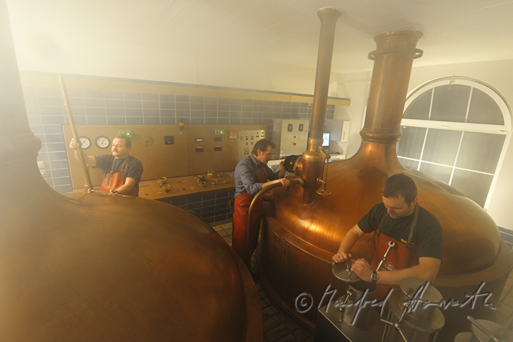 master brewer and workers brew beer in the brew house