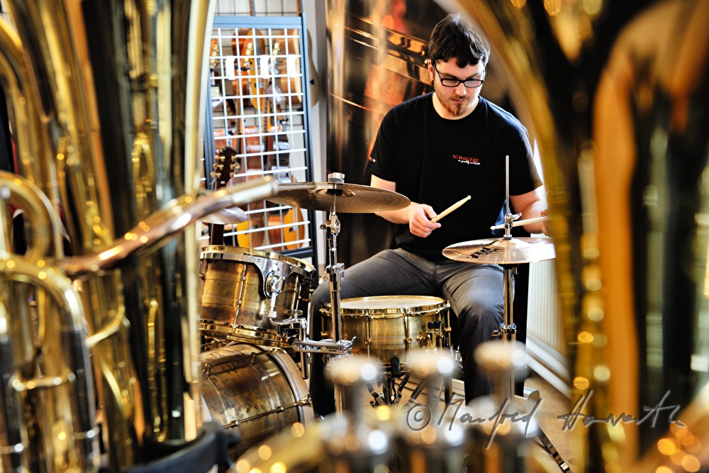 drummer plays a brass drum kit