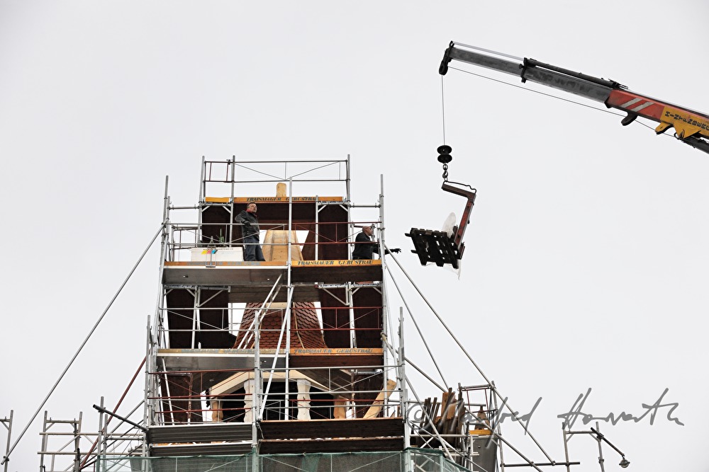 roof tiles are being lifted up to the roofers