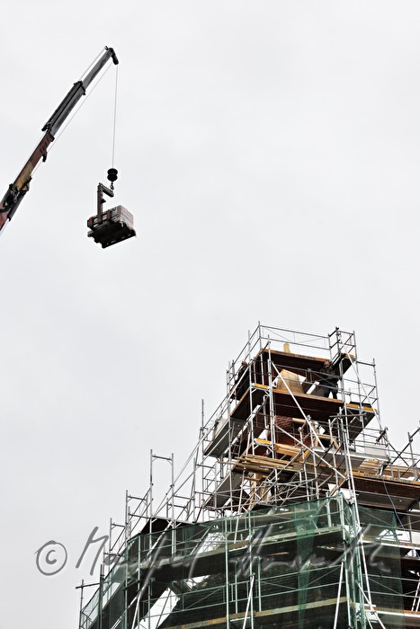 roof tiles are being lifted up to the roofers