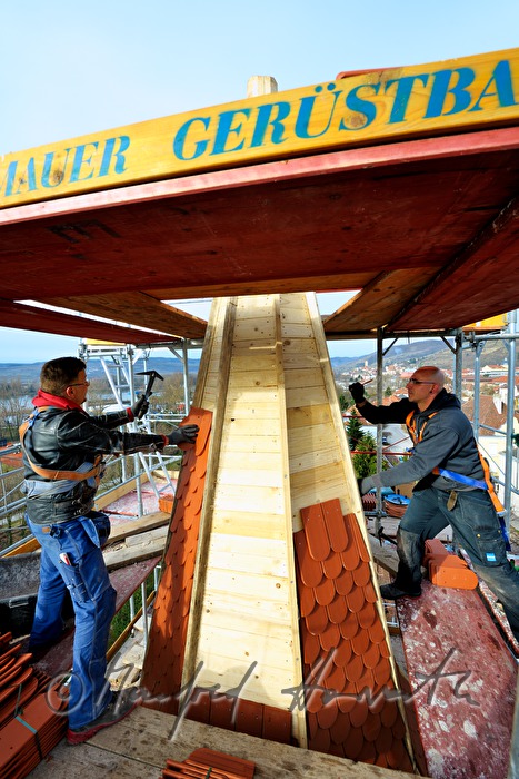 roofers work on the steeple of the church