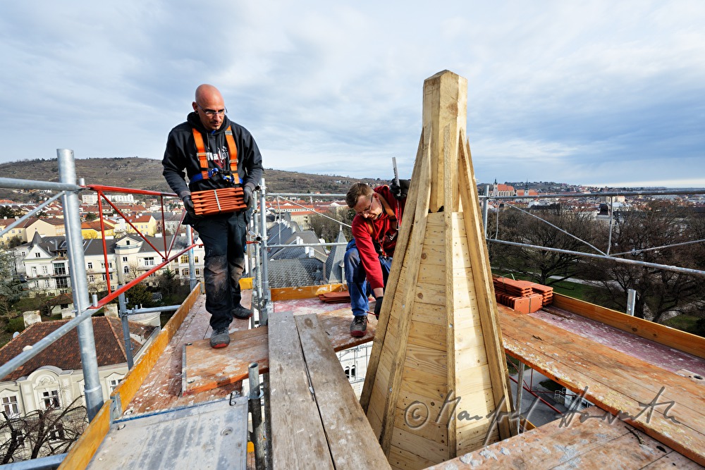 roofers work on the steeple of the church