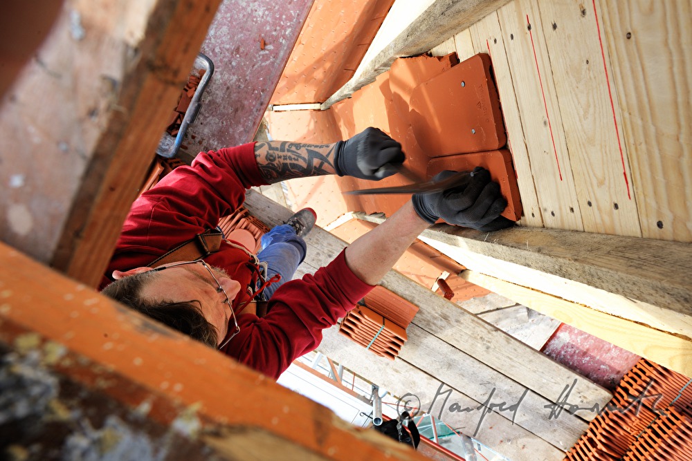 roofer works on the steeple of the church