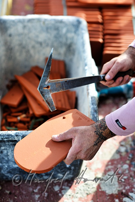roofer works on the steeple of the church