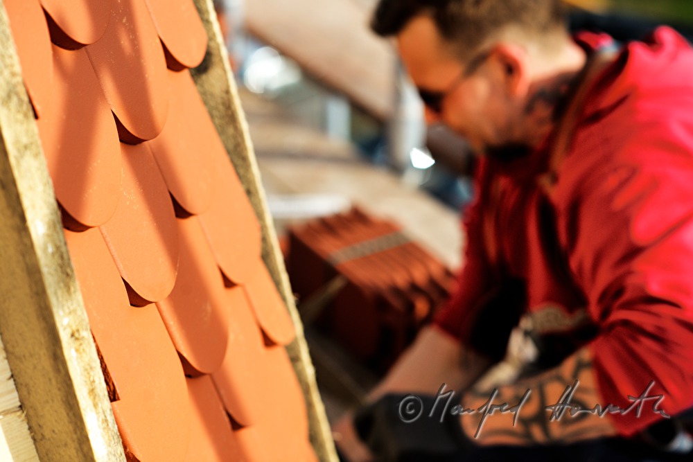 roofer works on the steeple of the church