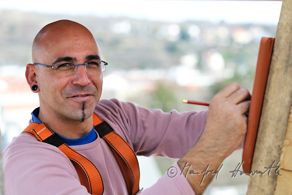 roofer works on the steeple of the church