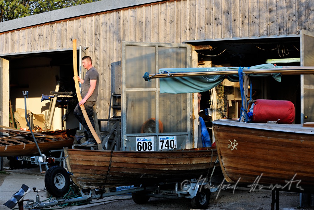 boat builder with a wooden plank