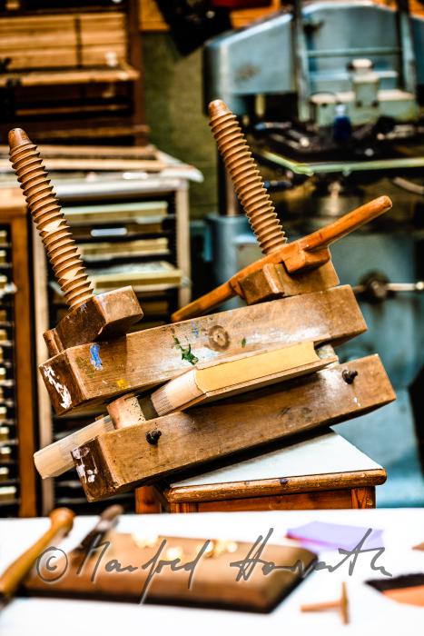 bookbinder Ernst Gstettenhofer squeezes a book with gilt edging