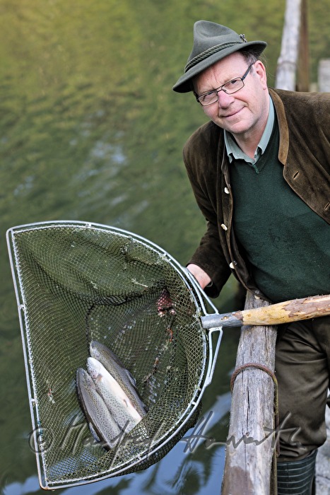 a fisherman is catching trouts with a casher