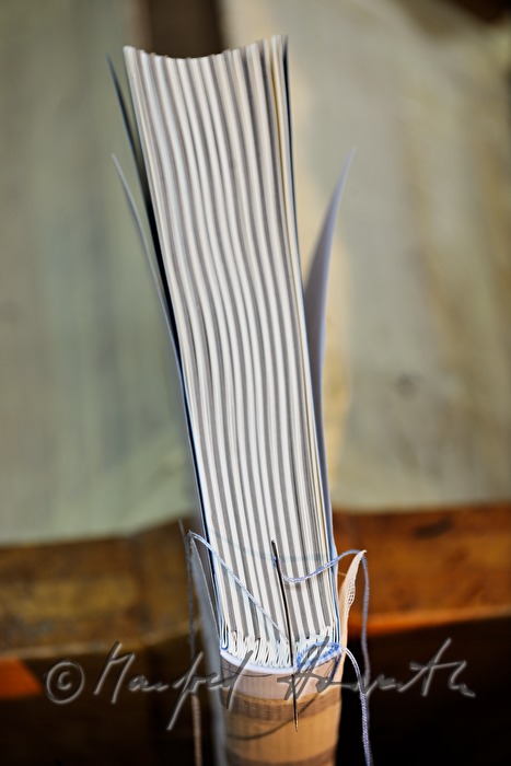 embroidering the capitals of a handbound book