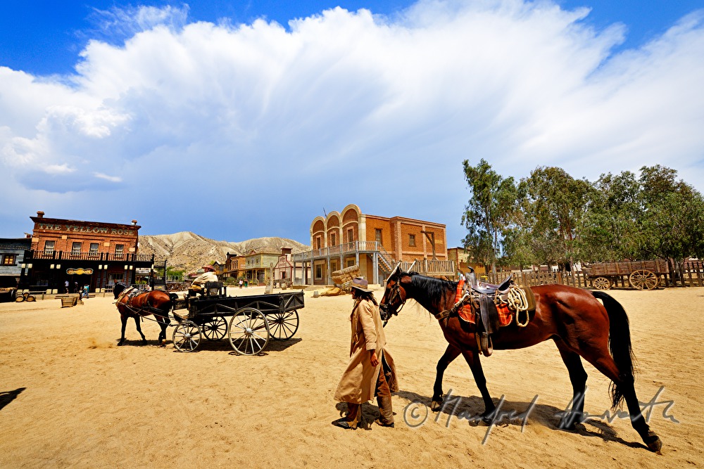 western performer cross the square of the Wild West town