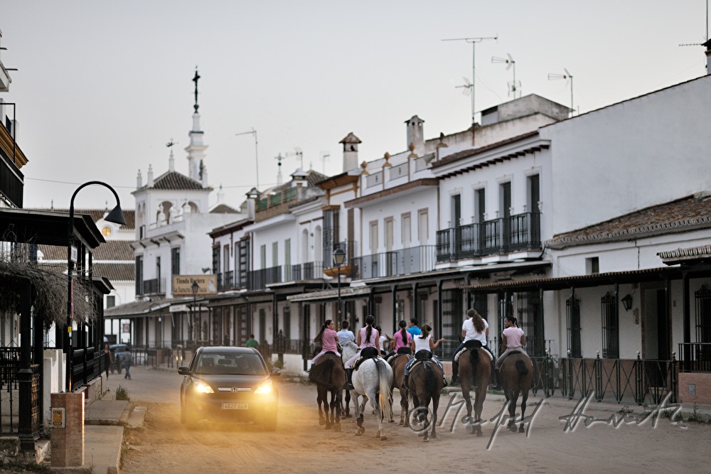group of horseback riders on the sandy main street