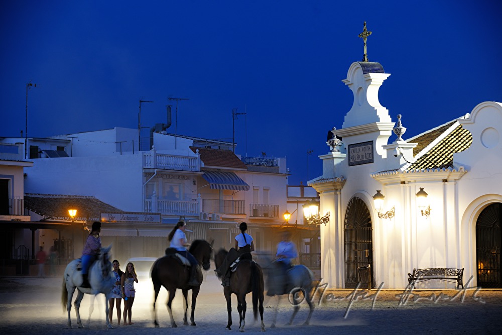 group of horseback riders on the sandy main street