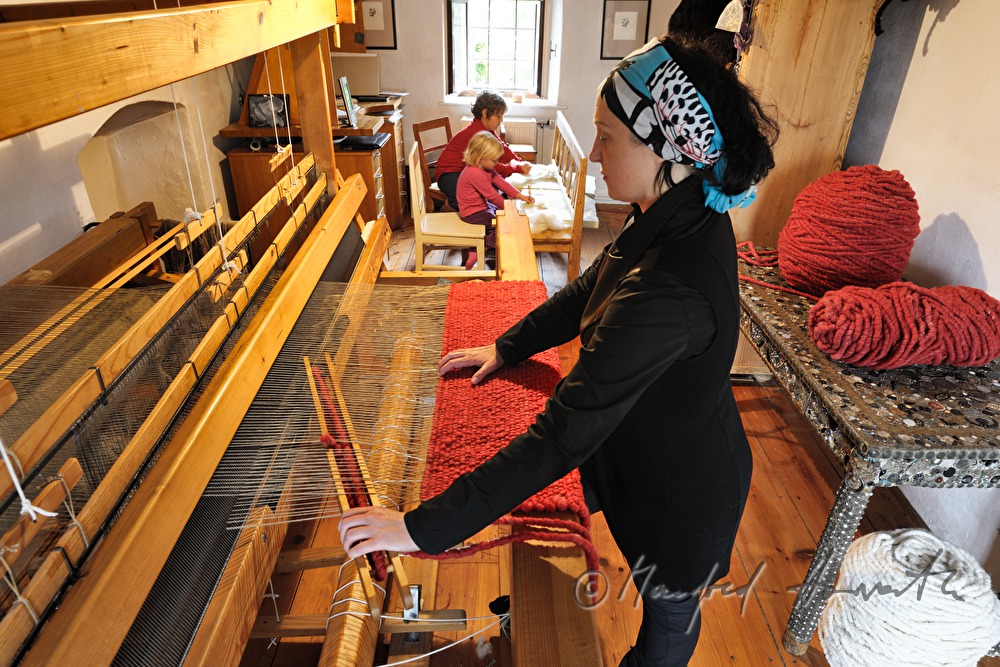 Barbara Schmidt weaves a wool carpet in her workshop
