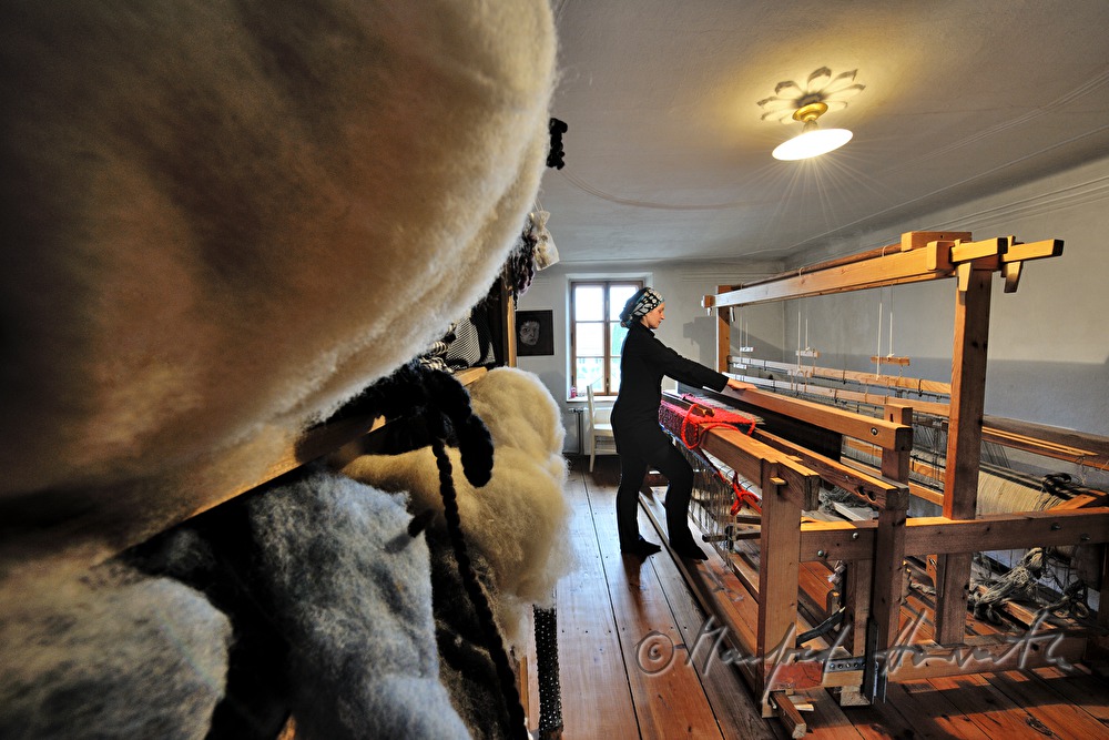 Barbara Schmidt weaves a wool carpet in her workshop