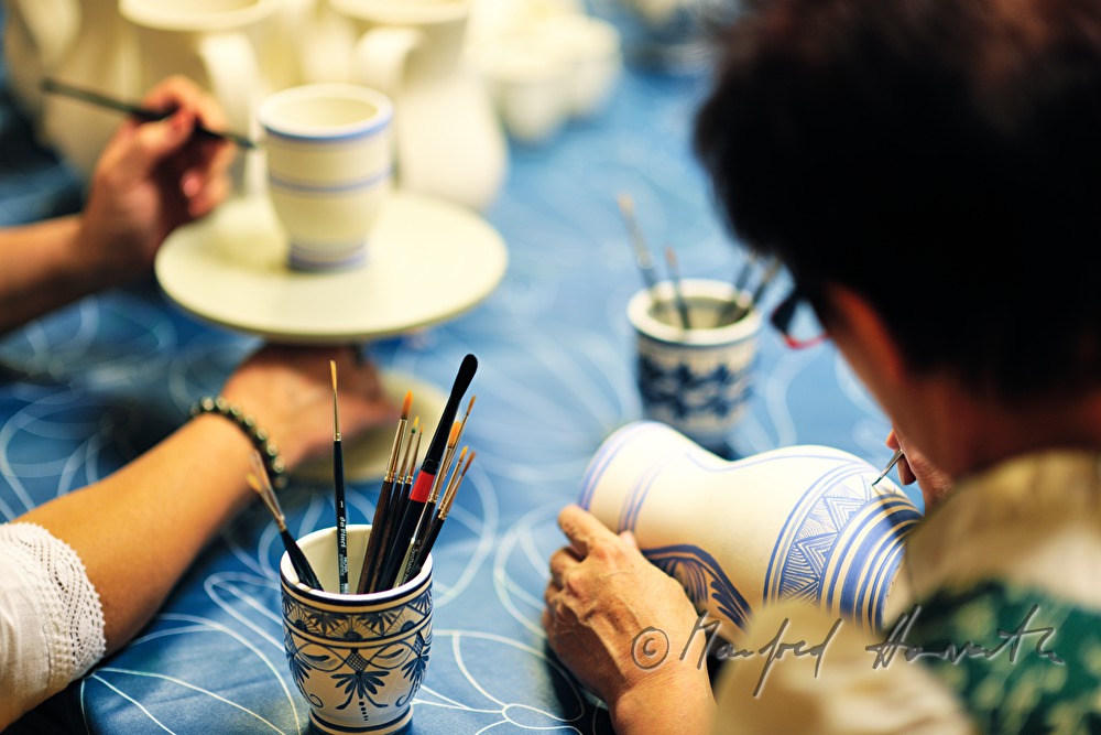 painting the pottery with blue pigments in the workshop of the pottery
