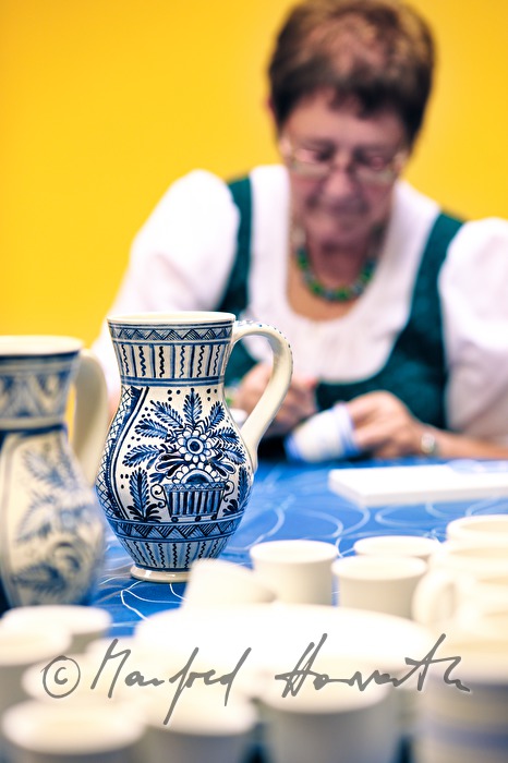 painting the pottery with blue pigments in the workshop of the pottery