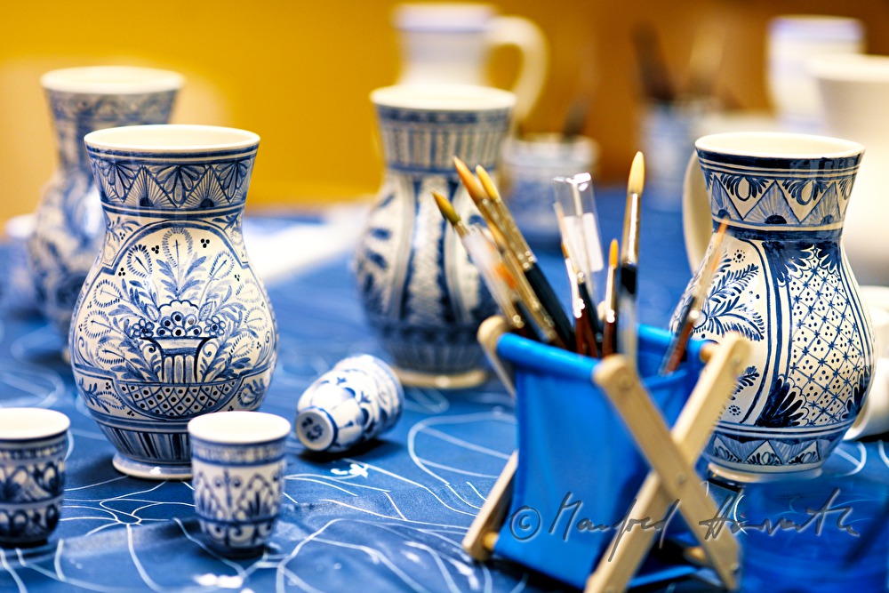 painting the pottery with blue pigments in the workshop of the pottery