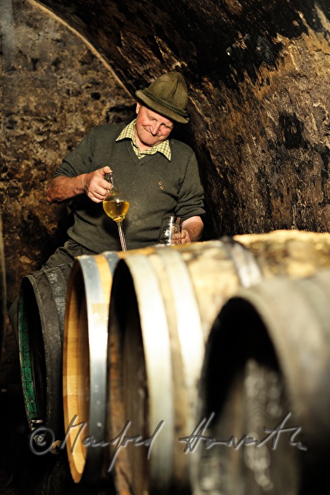 must farmer takes a tasting sample with a syphon