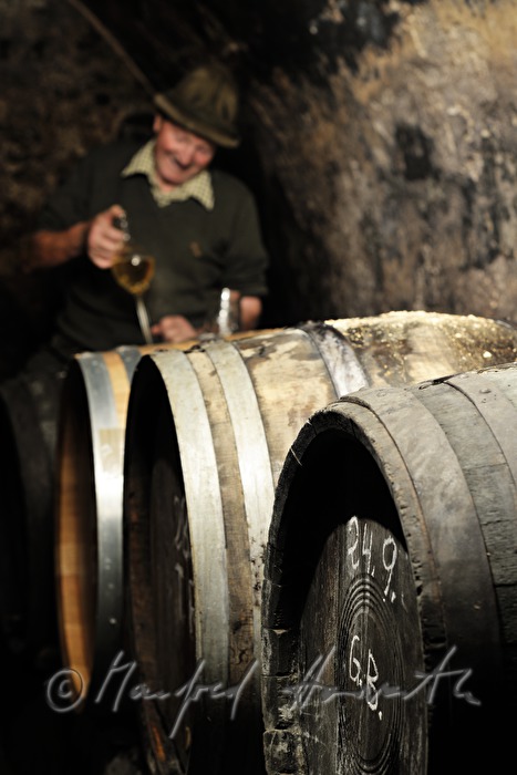 must farmer takes a tasting sample with a syphon
