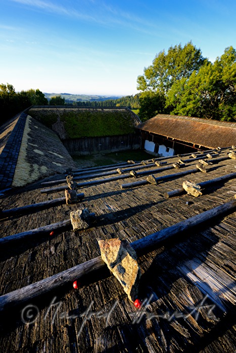 farmhouse with thached roof and stones on the shingle roof