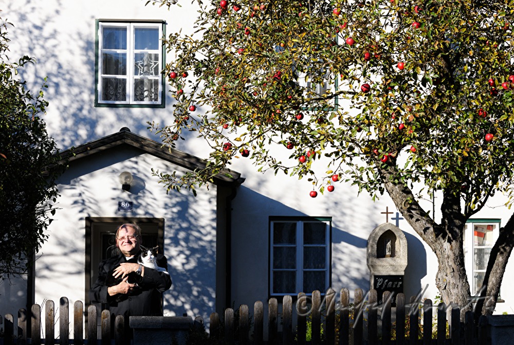 reverend Josef Kantusch with his cat in front of his parsonage